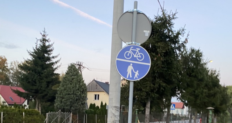 A blue traffic sign with a bike and people walking